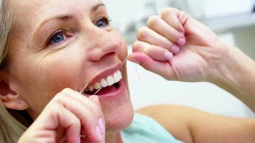 Woman flossing her teeth