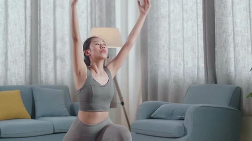 Young Asian Athletic Female Exercising, Stretching And Practicing Yoga At Home