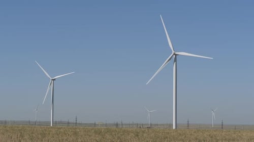 Wind Turbines Rotating in Rural Landscape on Sunny Day