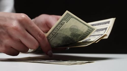 Woman's Hands Counting Hundred Dollar Bills