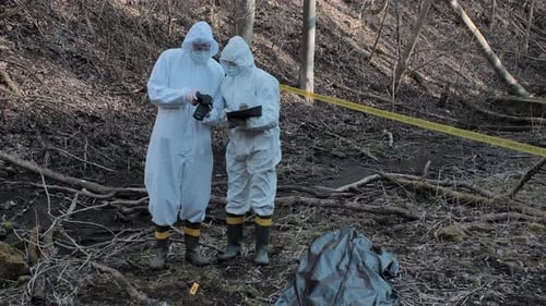Forensic specialists working in the forest. Crime scene and police concept.