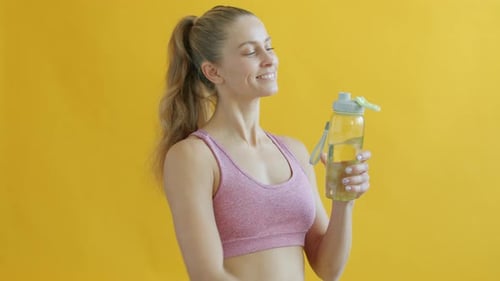 Woman Drinks Water After Fitness Training Session