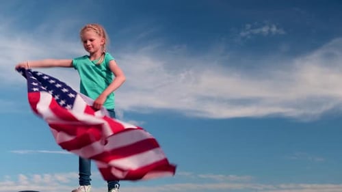 Child Waves American Flag Proudly on Sunny Day