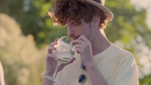 Young Adult Enjoying Drink Outdoors on Sunny Day