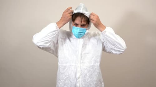 Man in Hazmat Suit Adjusts Medical Face Mask