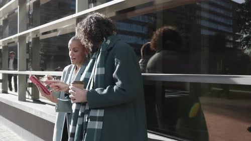 Colleagues Working Together on Tablet Outside Office Building