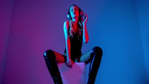 Woman Posing with Headphones in Colorful Lighting