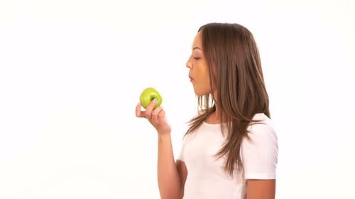 Beautiful Healthy Girl Biting a Juicy Green Apple, on White