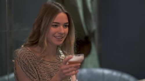 Portrait of Beautiful Young Woman Sitting in Cafe and Drinking Cocktail