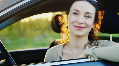 Woman Smiling and Relaxing in Her Car