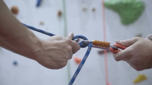 A Rock Climber Tie a Knot on a Rope. A Person Is Preparing for the Ascent. Man Learns To Tie a Knot