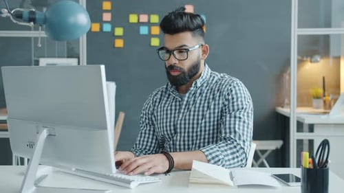 Mixed Race Guy Suffering From Headache Touching Head Working with Computer in Office