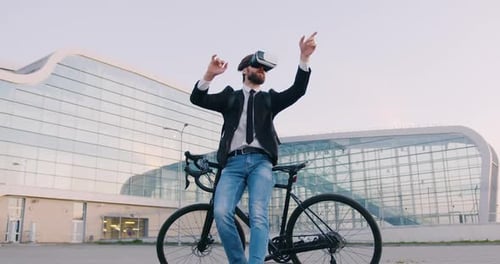 Homme d'affaires debout près de son vélo dans un casque de réalité virtuelle et travaillant sur un écran imaginaire