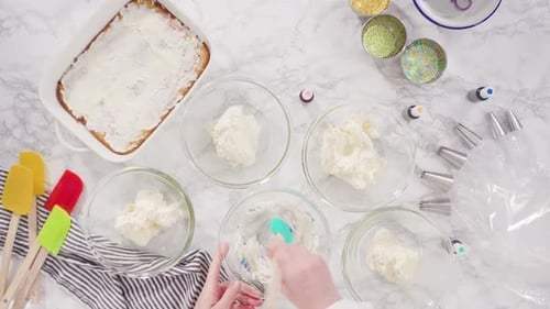 Flat lay. Mixing food coloring into Italian buttercream frosting.