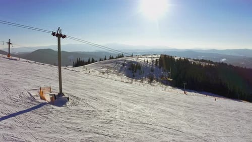 Alte Skistation an einem verschneiten Berghang mit vielen Leuten auf Skiern und Snowboards