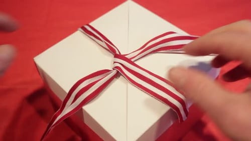 Hands Untying Bow From Christmas Present