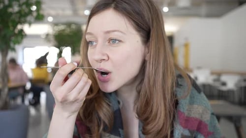Woman Eats Salad in Bright Cafe