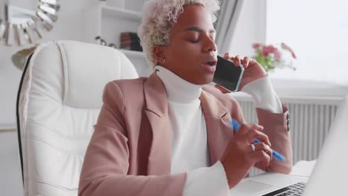 African American Business Woman Talking on Phone Using Laptop at Home Office