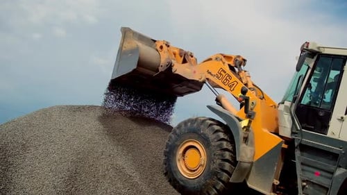 Front Loader Pouring Gravel onto Rock Pile