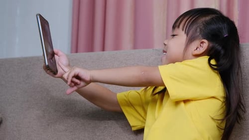 Girl Uses Smartphone on Couch Indoors