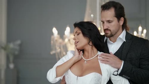 Elegant Couple Embraces Affectionately in Grand Interior