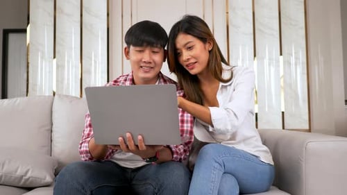 Couple Using Laptop on Couch at Home