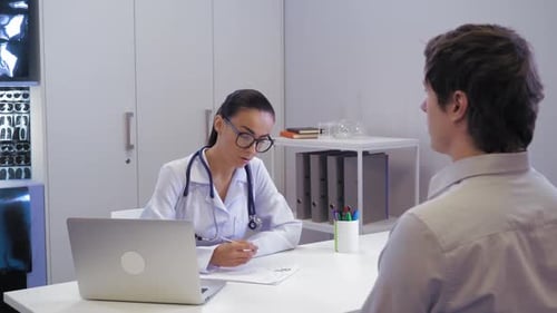 Doctor Consults With Patient in Bright Office