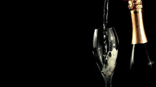 A Jet of Champagne Falls Into a Glass of Splashes and Foam