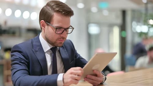Man Celebrates Success While Using Tablet Device