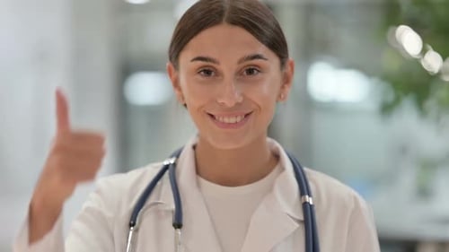 Smiling Doctor Giving Thumbs Up in Hospital