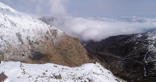 Aerial Flying Moving Forward Over Snowy Mountain Ridge Valley Near Lodge Establisher