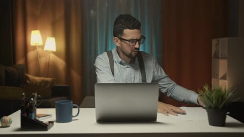 Focused Man Working Late at Home Office Desk