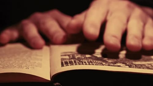 Hands Turning Pages of Vintage Book Close-Up