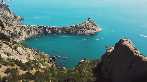 Rocks and Reefs Around a Picturesque Bay with Turquoise Water and Yachts on the Water. Drone Footage