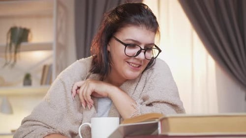 Woman Reading Books at Home in Cozy Setting