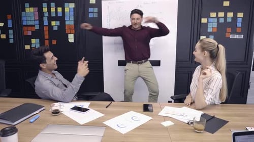 Young Adults Dancing at Boardroom After Success