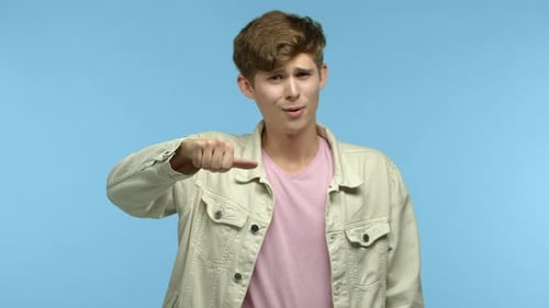 Arrogant Guy Mocking Someone Showing Thumbs Down Gesture and Shaking Head with Disappointment