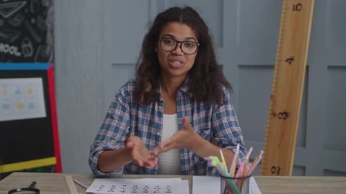 Smiling Woman Explaining Math at Desk