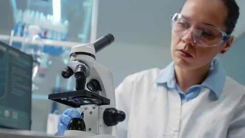 Woman Scientist Using Microscope in Bright Laboratory