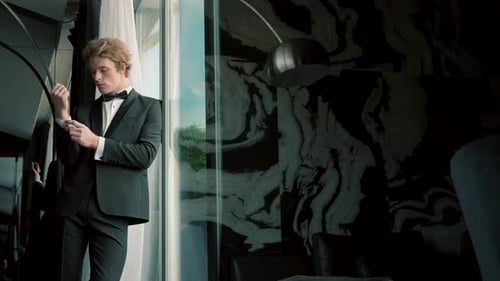 Man Adjusting Cuff in Tuxedo Near Window