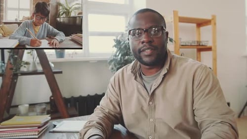 Afro-American Teacher Giving Online Lesson to Asian School Boy