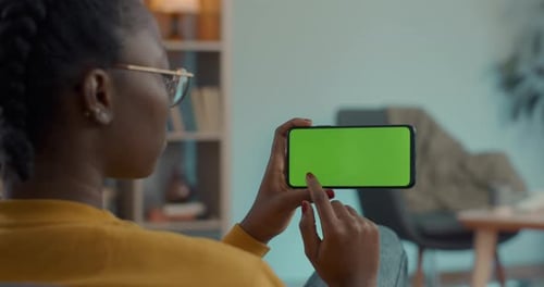 African American Woman Scrolling with Forefinger on Chroma Key Screen of Mobile