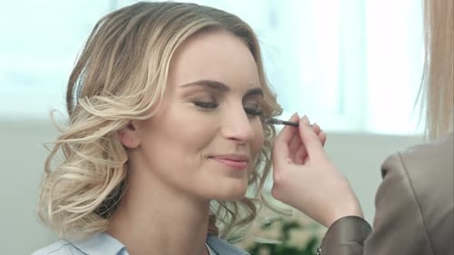 Woman Getting Mascara Applied to Eyelashes in Studio