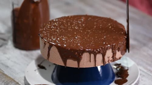 Chocolate Cake Being Decorated in Kitchen