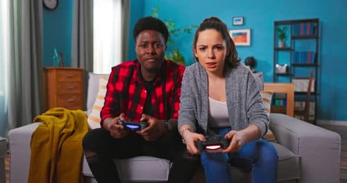 Smiling Young Couple Playing Video Games at Home