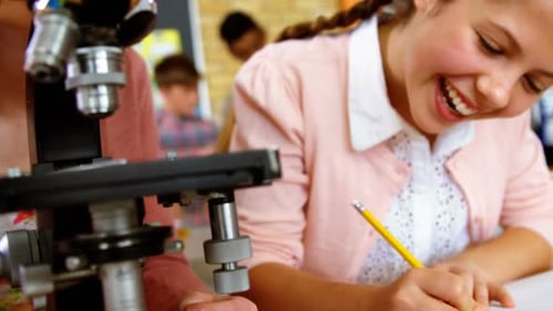 Aufmerksame Schüler schauen im Labor durchs Mikroskop
