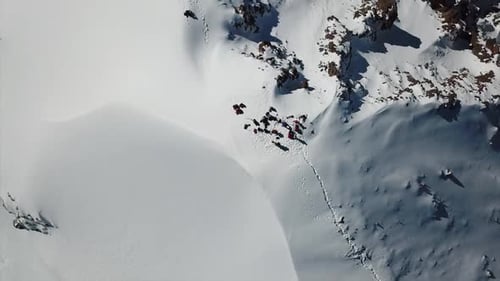 A Group of Climbers Climb to the Top of the Peak