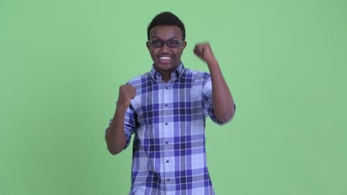 Glücklicher junger afrikanischer Hipster-Mann bekommt gute Nachrichten