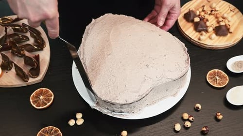 Woman baker is making cream chocolate cake, hands close up.