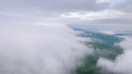 Flying through the clouds above the mountain peak.